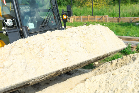 Sand for construction works is collected in a loader bucket.