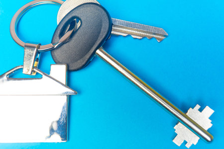 keys to the house with a keychain in the shape of the house..