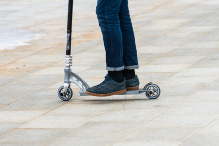 Scooter close-up. Man riding a scooter in the winter on the paving slabs