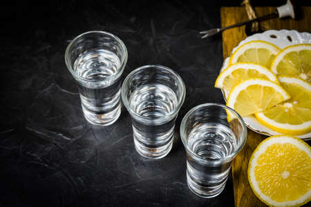 Strong alcohol poured into a glass. lemon slicing. Strong alcohol poured into a glass. lemon slicing.の写真素材
