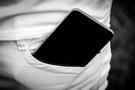 Mobile phone in pocket white jeans. Place for your text. Mobile phone in pocket white jeans. Place...