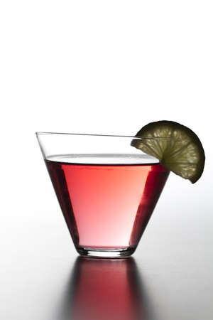 Red cocktail with slice of lemon shot on white backgroundの写真素材