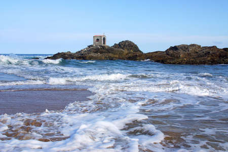 partial view of a wave and a small cliff with a chapell in the bay of San Agustinillo in the southern state of Oaxaca in  Mexico, Latin Americaの写真素材