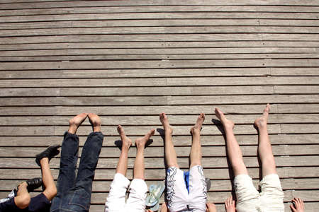bar feeted people enjoying the sun at the Rambla del Mar  at the city of Barcelona, Catalunya, Spain, Europeの写真素材