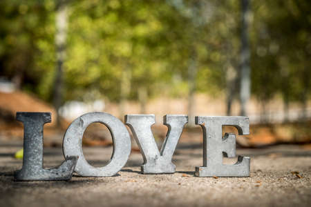 message of love with metal letters in a road in autumn seasonの写真素材