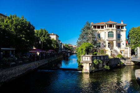 L'Isle-sur-la-Sorgue, France - July 18, 2016: Brightly colored awnings of outdoor cafes line the edges of the Sorgue River in the heart of L'Isle-sur-la-Sorgue, Provenceのeditorial素材