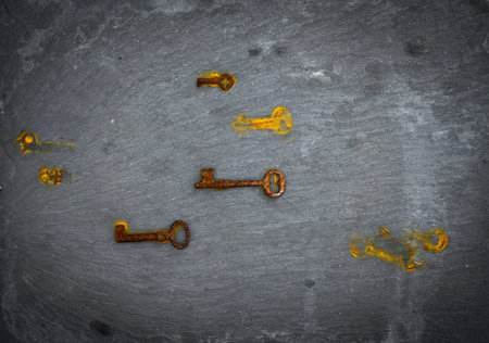 keys with rust marks photographed from above on a black stone background