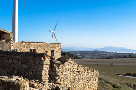 wind turbines in between agricultural fields and an abandoned old town in Catalonia Spain