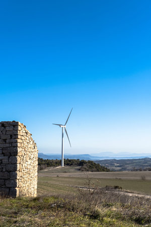 wind turbines in between agricultural fields and an abandoned old town in Catalonia Spain