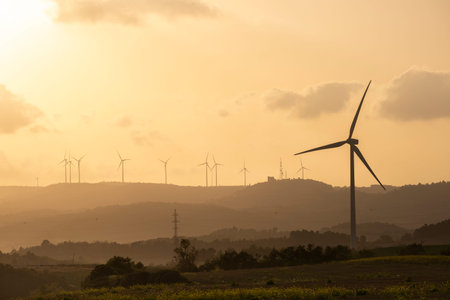 Wind turbines at sunset with the sky in the background