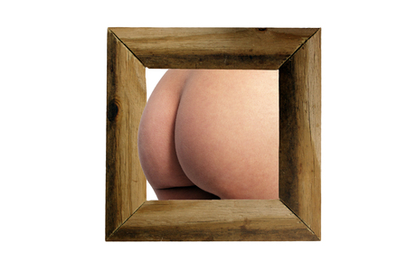 A perfect female ass emerges from a rustic wood frame, isolated on a white background with generous copyspace.の写真素材