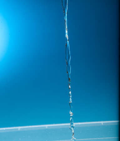 Water stream on a blue background.の写真素材