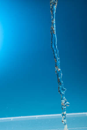 Water stream on a blue background.の写真素材