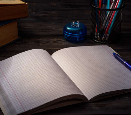 Busy student's wooden desk with open notebookの写真素材