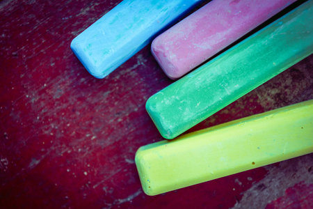 Colored chalk sticks on old wood board as copy space background. Education or back to school conceptの写真素材