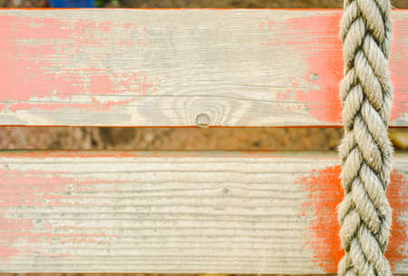 Old rope on background of distressed red painted wood planksの写真素材
