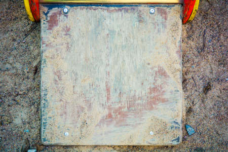 A worn old wood desk texture in the sand and mud as a background. The texture of the paint wooden plank with scratches and rough edgesの写真素材