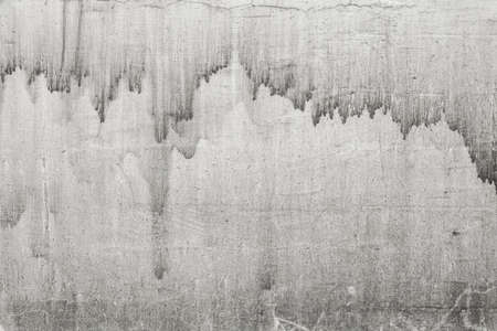 Rustic light grey concrete wall photo texture. Old concrete surface with drips and dirt. Distress texture with dark leak. Shabby chic backdropの写真素材