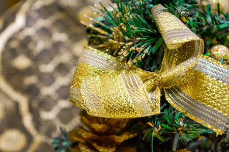 Closeup photo of little artificial green Christmas and New Year Fir-Tree with gold foil wrapped gift...