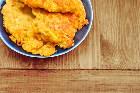 Diet vegetable cutlet from carrot, zucchini, potato on blue plate on wooden table. Healthy food....