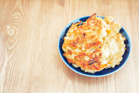 Diet vegetable cutlet from carrot, zucchini, potato on blue plate on wooden table. Healthy food. Close up viewの写真素材