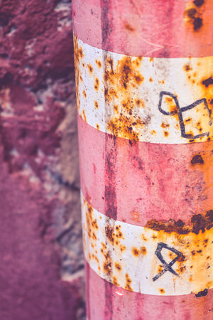 Old rustic Bollard or Traffic pole. Sign for cars with white and red horisontal stripes near the...