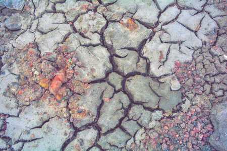 Dry mud ground with crack texture and granite gravel. Dry dirty soil on summer landscape. Cracks on...