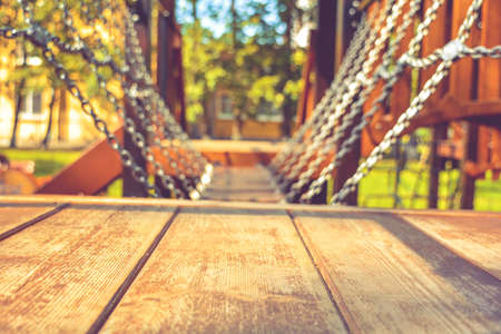 Close-up of swinging platform, hangs on chains in children's playground on sunny summer day as backdrop for outdoor activities and children's sports. Children's sports equipment on blurred backgroundの写真素材