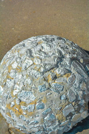 Silver paint rough hemisphere limiter of parking from small stones or pebbles and concrete for cars on asphalt of city street. Element of sidewalk design and protection from car parkingの写真素材
