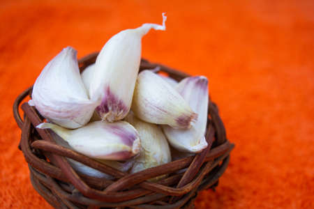 Cloves of raw Garlic in wooden small vintage nest of bird as bowl. Spices for cooking - garlicの写真素材