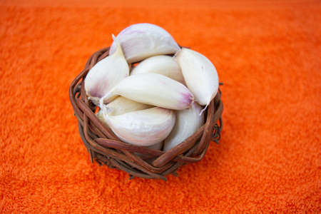 Cloves of raw Garlic in wooden small vintage nest of bird as bowl. Spices for cooking - garlicの写真素材