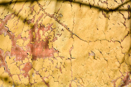 Old grunge messy plaster wall with peels of paint. Rough urban concrete wall texture with damagesの写真素材