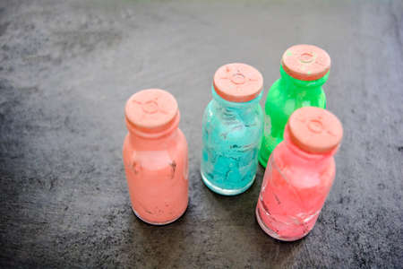Set of small whole and cracked glass bottles with rubber corks and dried old artistic paint. Close up of watercolor paint bottlesの写真素材