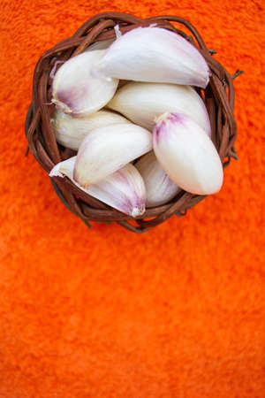 Cloves of raw Garlic in wooden small vintage nest of bird as bowl. Spices for cooking - garlicの写真素材