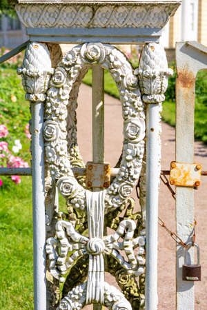 Decorative element of vintage forged white fence with garlands of flowersの写真素材