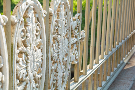 Historical vintage white cast iron fence with openwork lattice ellipse decorative ornametal elementsの写真素材