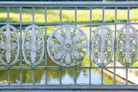 Historical vintage white cast iron fence with openwork lattice ellipse decorative ornametal elementsの写真素材