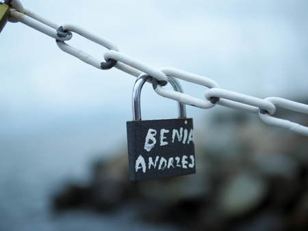 Key love locks hang from a chain, representing secure friendship and forever love.の写真素材