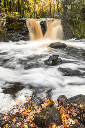 Root Beer Falls in Wakefield Michigan in the Upper Peninsula of Michigan. Tannin colored water flows over rock and spills into Planter Creekの写真素材