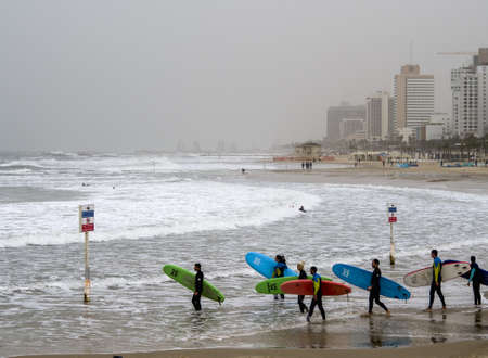Tel Aviv, Israel - 12/15/2019: surfers training with their board on the waves of seaのeditorial素材