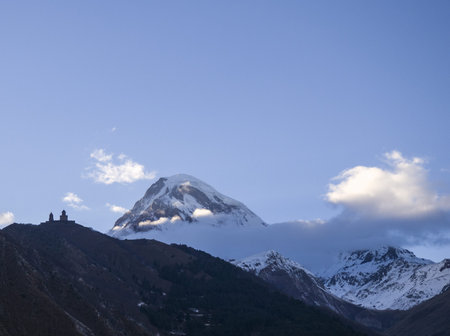 Kazbegi Mountain in Georgia - with some clouds on it and snow.