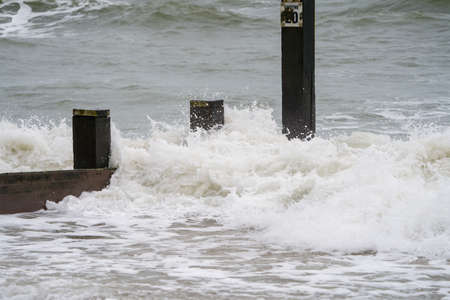 Stormy sea waves breaking on the pier. Stormy weather.の写真素材
