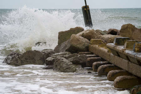 Sea waves breaking on the breakwater. Stormy weather in the sea.の写真素材