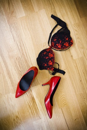 fashionable female shoes and bra on wooden floorの写真素材