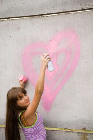 girl painting on the gray and dirty wallの写真素材