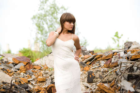 fashionable girl in white dress on the dirty industrial placeの写真素材