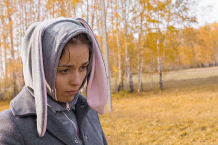 sadness girl in bunny suit on a nature backgroundの写真素材