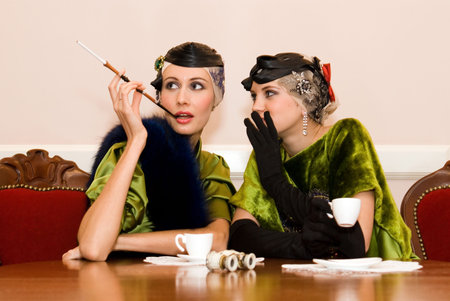 two beauty talking girls sit sitting at the wood tableの写真素材