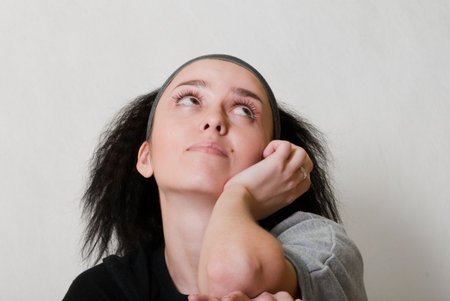 beauty dreaming girl with black hair on gray backgroundの写真素材