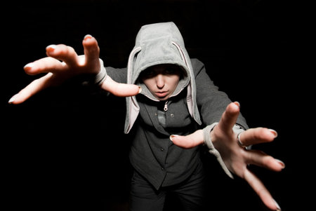 girl pulls hand and horrify on black backgroundの写真素材